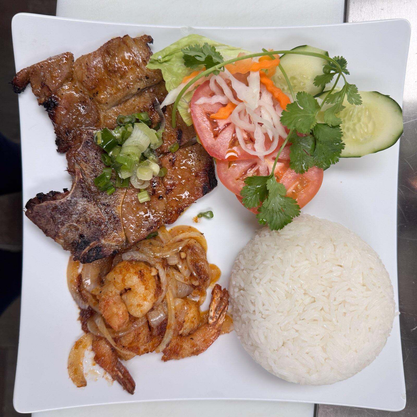 Grilled pork chop and simmering shrimp rice plate.